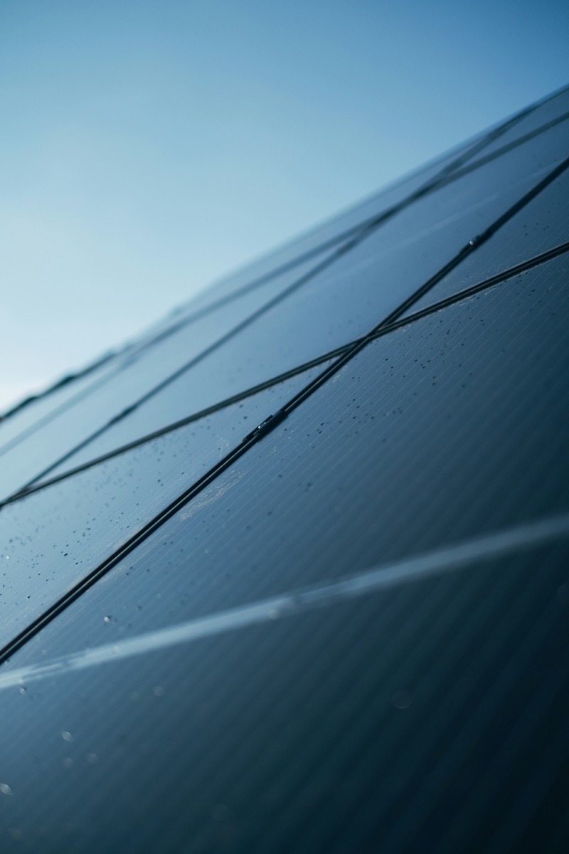 Close-up of a solar panel surface beaded with water droplets